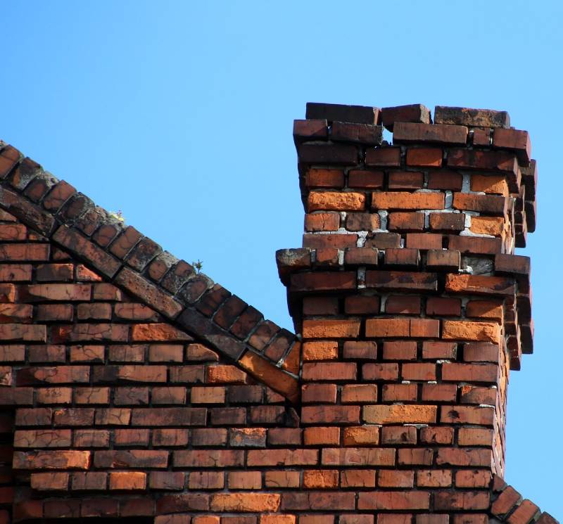 Damaged chimney on an Webster home showing cracks and missing mortar